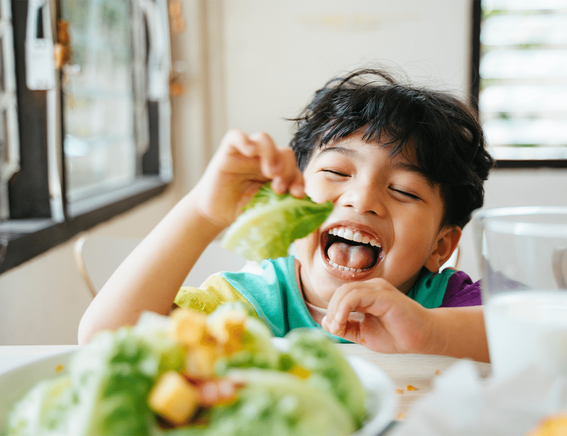 Kanopi-ACCFB_CS_1 Smiling child eating healthy meal with vegetables